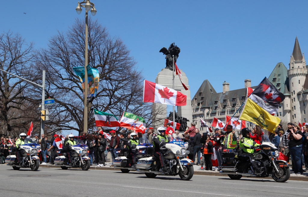 I poliziotti in moto superano una manifestazione, parte di una manifestazione in stile convoglio chiama "Rombo di tuono" A Ottawa, Ontario, sabato 30 aprile 2022.