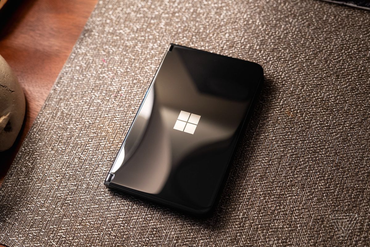 Microsoft Surface Duo 2 nero chiuso e seduto su un materasso.