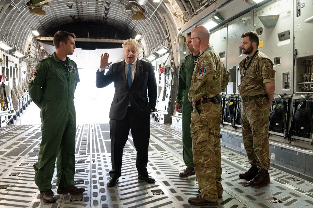 Boris Johnson parla con il sergente dello squadrone Air Loadmaster 99 Tom Clare, ufficiale al comando del 99° squadrone Wing Commander Will Essex e ufficiale al comando dell'ala operativa della RAF Brize Norton Wing Commander Andy Hampshire dopo il ritorno da Kiev.
