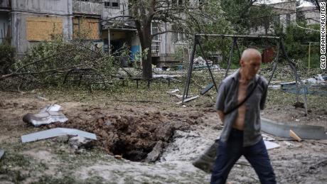 Un residente locale passa davanti a un condominio distrutto da un attacco missilistico, durante l'invasione russa dell'Ucraina, a Bakhmut, in Ucraina, il 13 giugno 2022. 