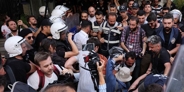 Gli agenti di polizia impediscono ai giornalisti di filmare e fotografare gli attivisti detenuti mentre tentano di marciare in una manifestazione dell'orgoglio bandita dalle autorità locali nel centro di Istanbul, Turchia, 26 giugno 2022 (Reuters/Umit Bektas)