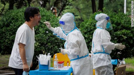 Un operatore sanitario preleva un campione di tampone in una stazione di test del DNA a Pechino il 6 luglio.