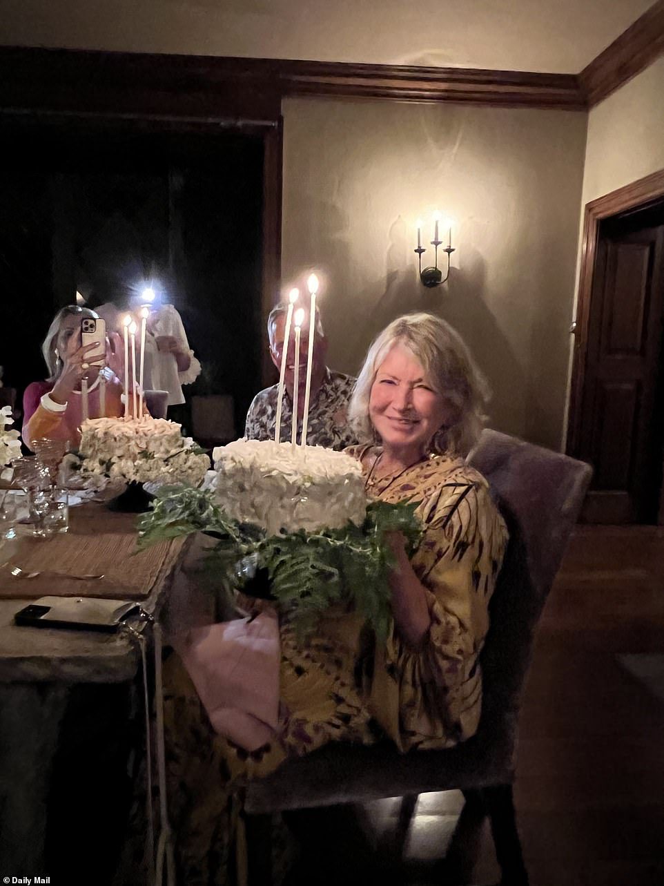 Incandescente: la donna d'affari posa con la sua torta per scattare un'altra foto della sua fantastica festa