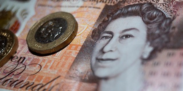 Moneta britannica da due libbre posta sopra una banconota da 10 libbre della Banca d'Inghilterra con il ritratto della regina Elisabetta II.