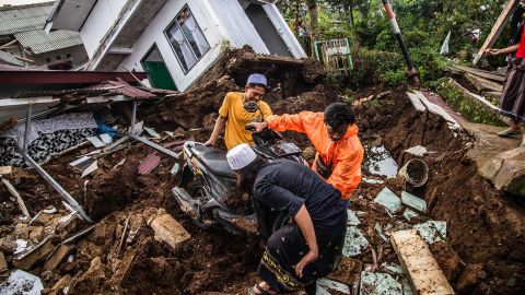 Gli abitanti dei villaggi recuperano oggetti dalle case danneggiate dopo un terremoto di magnitudo 5,6 a Cianjur il 22 novembre 2022. 